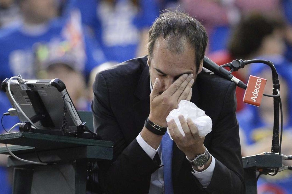 Umpire Arnaud Gabas, of France, holds his face after being hit by a ball during first-round Davis Cup tennis match action between Canada's Denis Shapovalov and Britain's Kyle Edmund, Sunday, Feb. 5, 2017, in Ottawa, Ontario. (Justin Tang/The Canadian Press via AP)