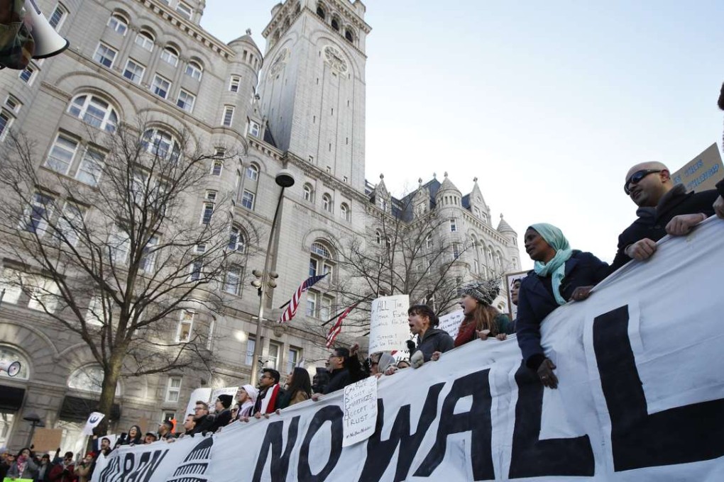 Protesters march along Pennsylvania Avenue past the Trump International Hotel during a rally protesting the immigration policies of President Donald Trump, near the White House in Washington. Photo: AP