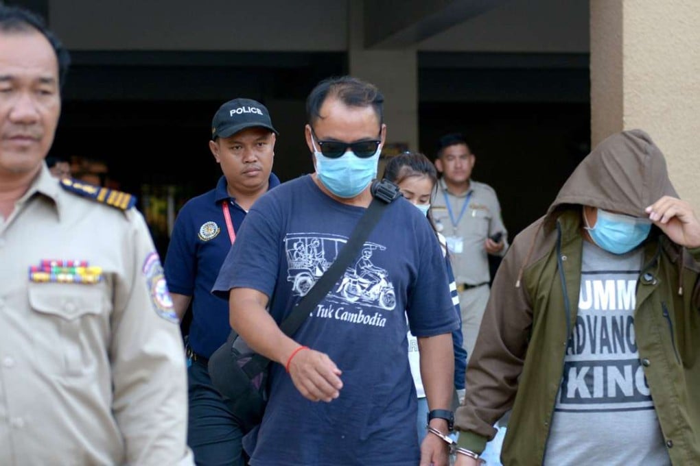 Arrested Japanese national Susumu Fukui and a Cambodian man and woman are escorted by police at the Phnom Penh Municipal Court. Photo: AFP