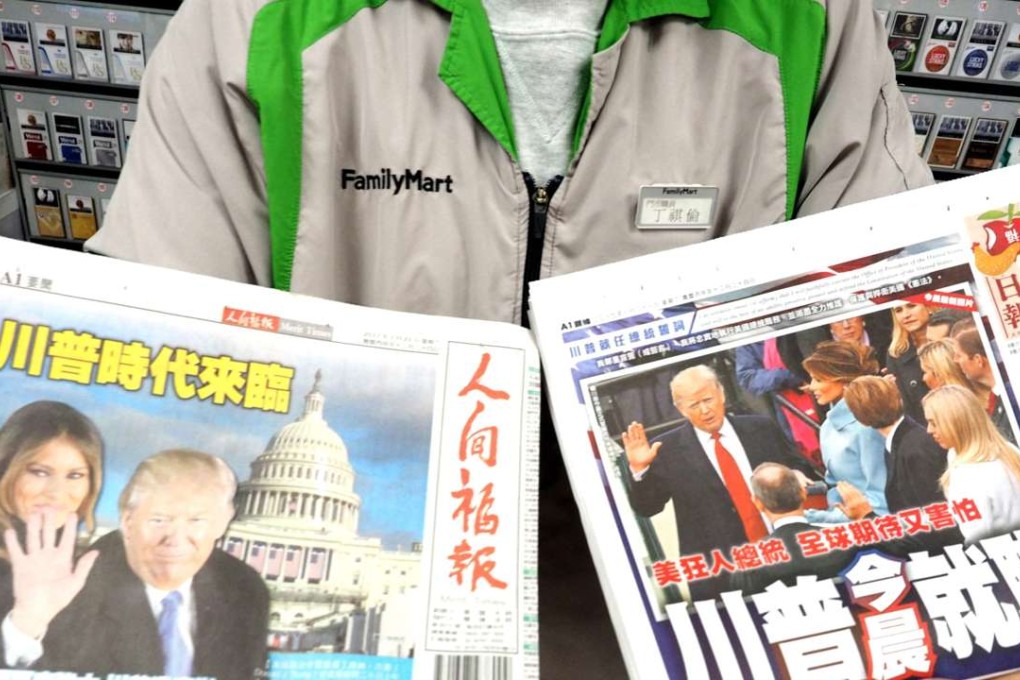 A shop clerk displays newspapers which report Donald Trump's inauguration as US president in Taipei on January 21. The one-China policy has served as the basis for Sino-US ties since 1979, and altering it would be dangerous, the experts said. Photo: Photo: EPA