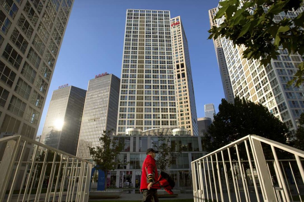 A pedestrian walks through a shopping and office complex on a blue-sky day in Beijing. China’s polluted air is still largely hazardous to health. Photo: AP