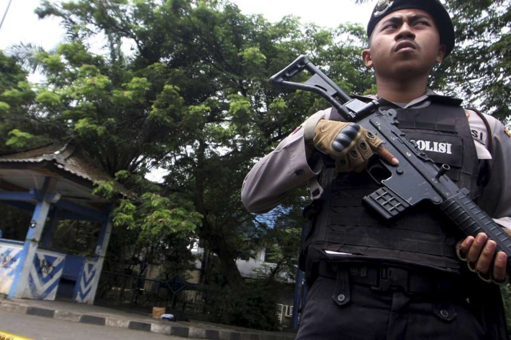 A policeman holds a rifle at a location where a suspected supporter of Islamic State attacked policemen in Tangerang, Indonesia's Banten province. Photo: Reuters.