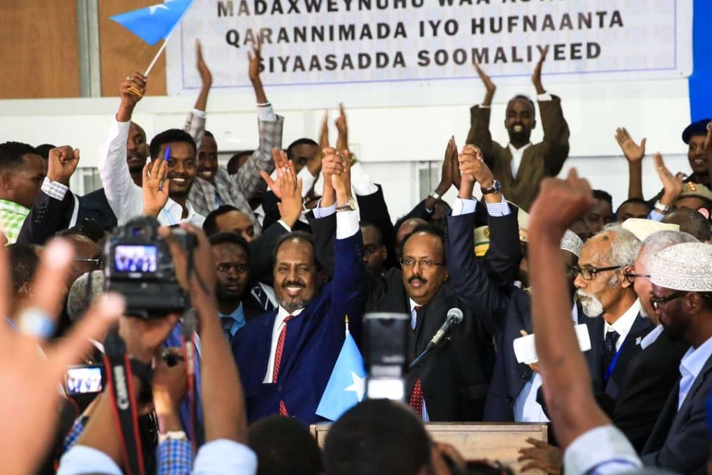 Mohamed Abdullahi Farmajo (centre right) raises his hands in victory after winning the presidency of Somalia. He is lictured with outgoing President Hassan Sheikh Mohamud in Mogadishu. Photo: Xinhua