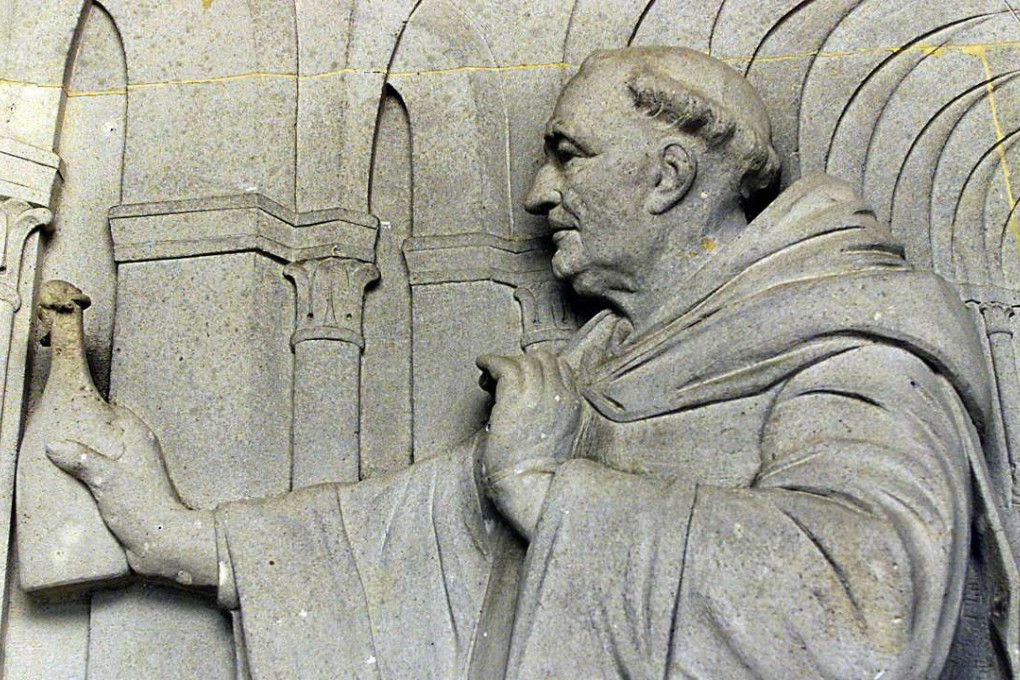 A carving of the monk Dom Pérignon and a bottle of his namesake wine. Picture: AFP