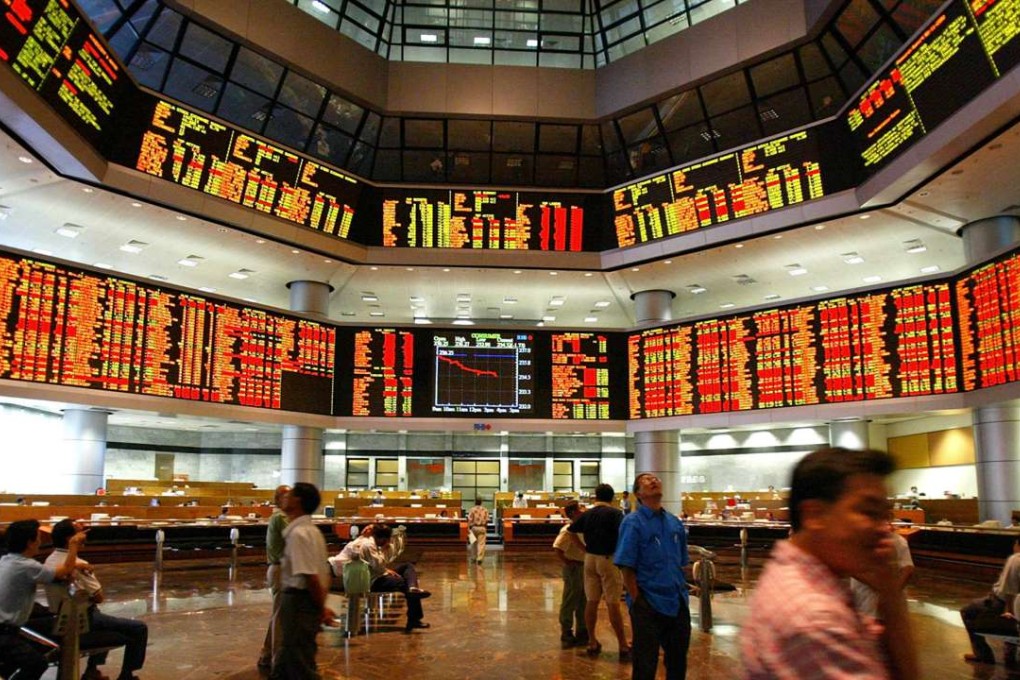 Investors monitor share prices from electronic display boards of the Kuala Lumpur Stock Exchange at the RHB trading floor in Kuala Lumpur. Photo: Jimin LAI/AF
