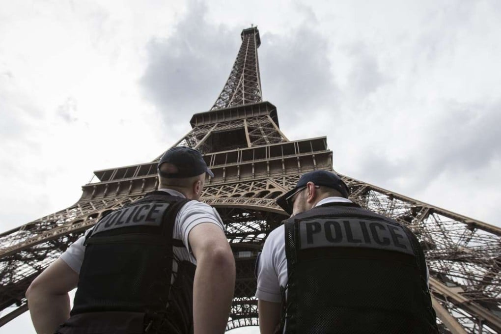 French police officers patrol under the Eiffel Tower. Paris authorities said they are proposing to replace the metal security fencing around the tower with a glass wall. Photo: AP
