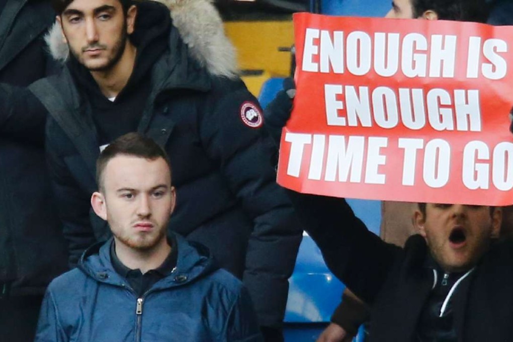 An Arsenal fan holds up a banner calling on manager Arsene Wenger to quit. Photo: AFP