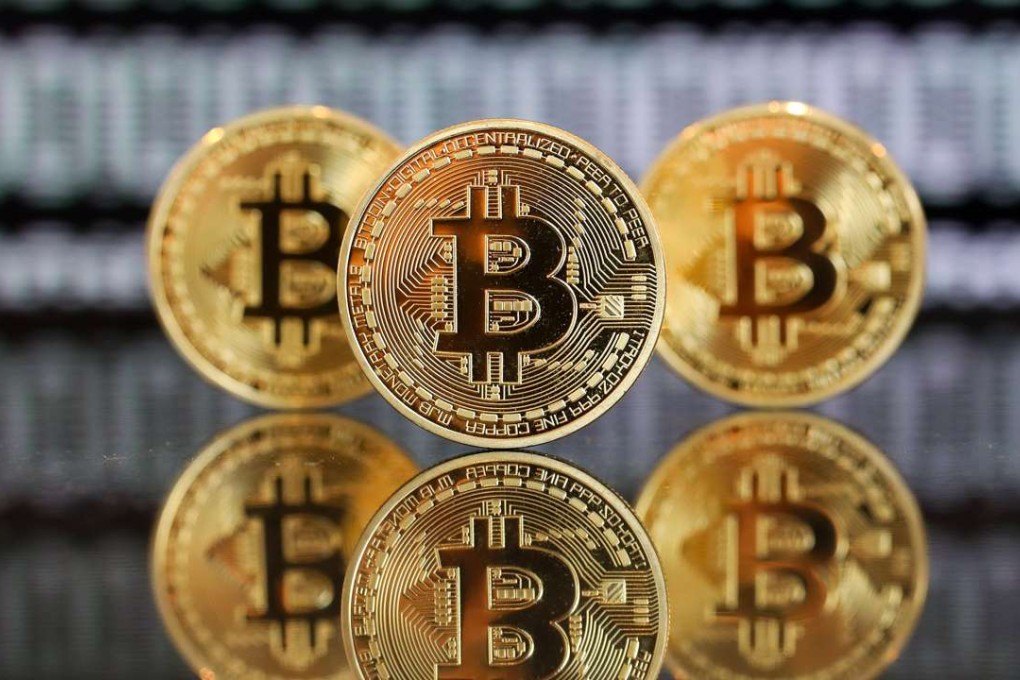A collection of bitcoin tokens stand in front of an illustration of binary code in this arranged photograph in London. Photo: Bloomberg