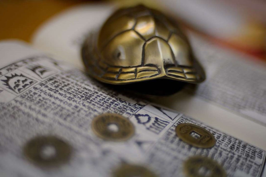 A metal turtle shell and Chinese coins that are used for predictions are seen in the office of a Hong Kong feng shui practitioner. Photo: AFP
