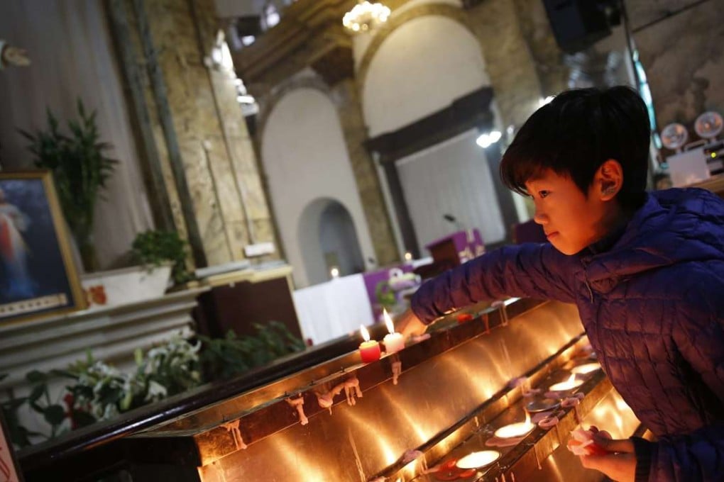 A file picture of a boy lighting candles at a state-approved Catholic church in Beijing. Photo: EPA