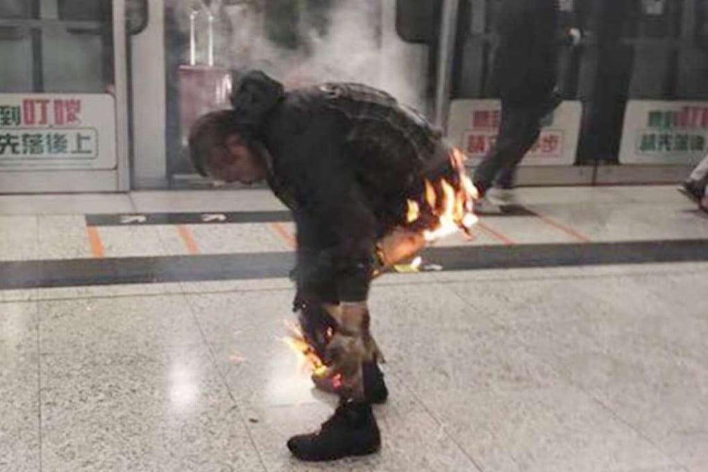 Man tries to extinguish flames after a firebomb sets off blaze in Hong Kong’s MTR. Photo: Facebook