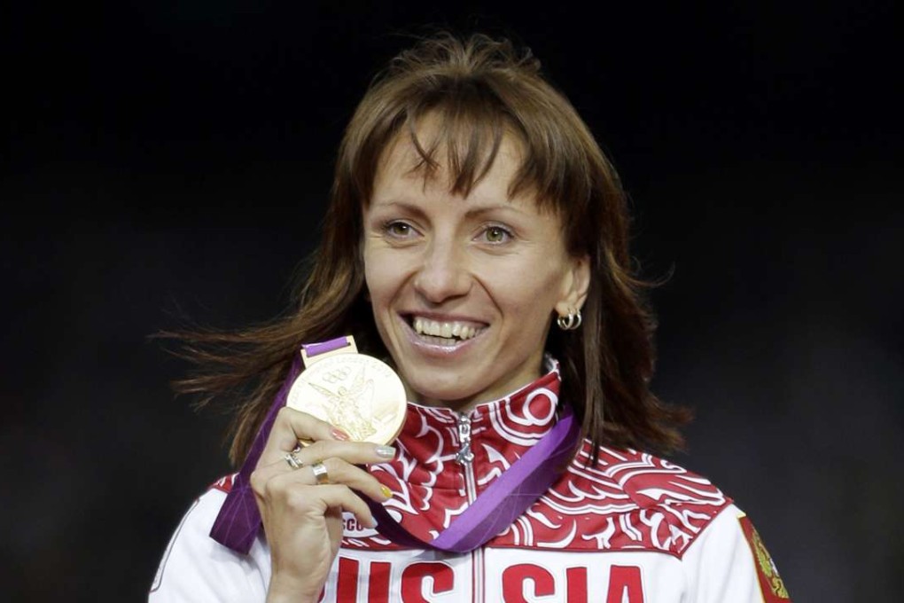 Mariya Savinova-Farnosova shows off her gold medal on the podium at the London Games. Photo: AP