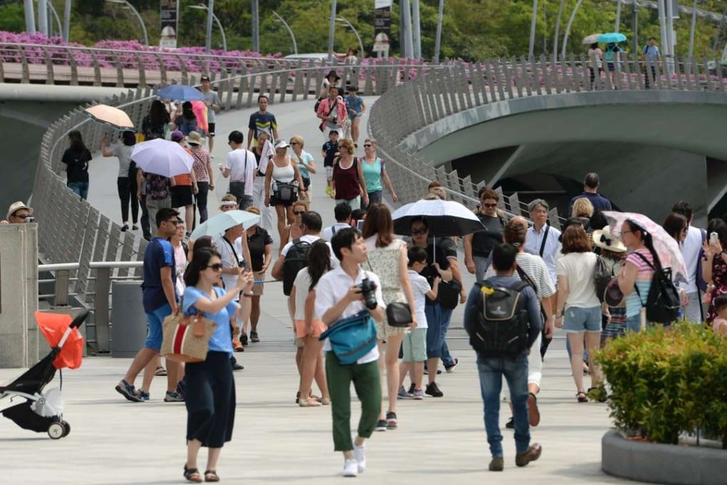 People walk along the bridge at Merlion park in Singapore. The city state’s workers are being urged to learn new skills. Photo: AFP