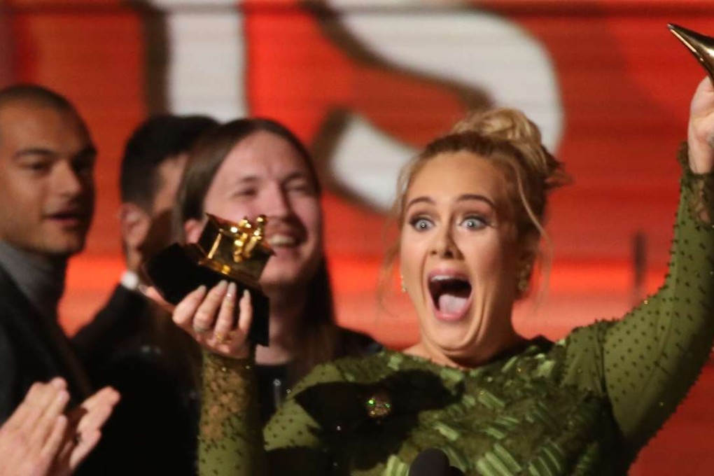 Adele accidentally breaks her Grammy for Record of the Year for Hello after having it presented to her at the 59th Annual Grammy Awards in Los Angeles. Photo: Reuters