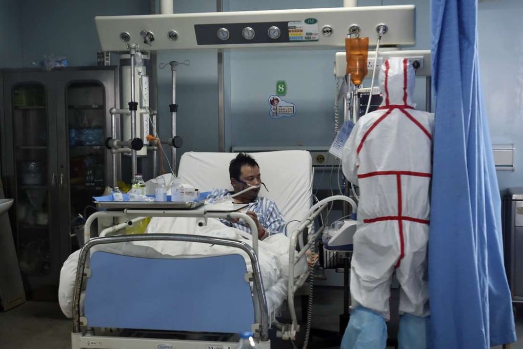 A patient infected with the bird flu virus in Wuhan in Hubei province is pictured on Sunday receiving treatment from a medical worker. Photo: AP