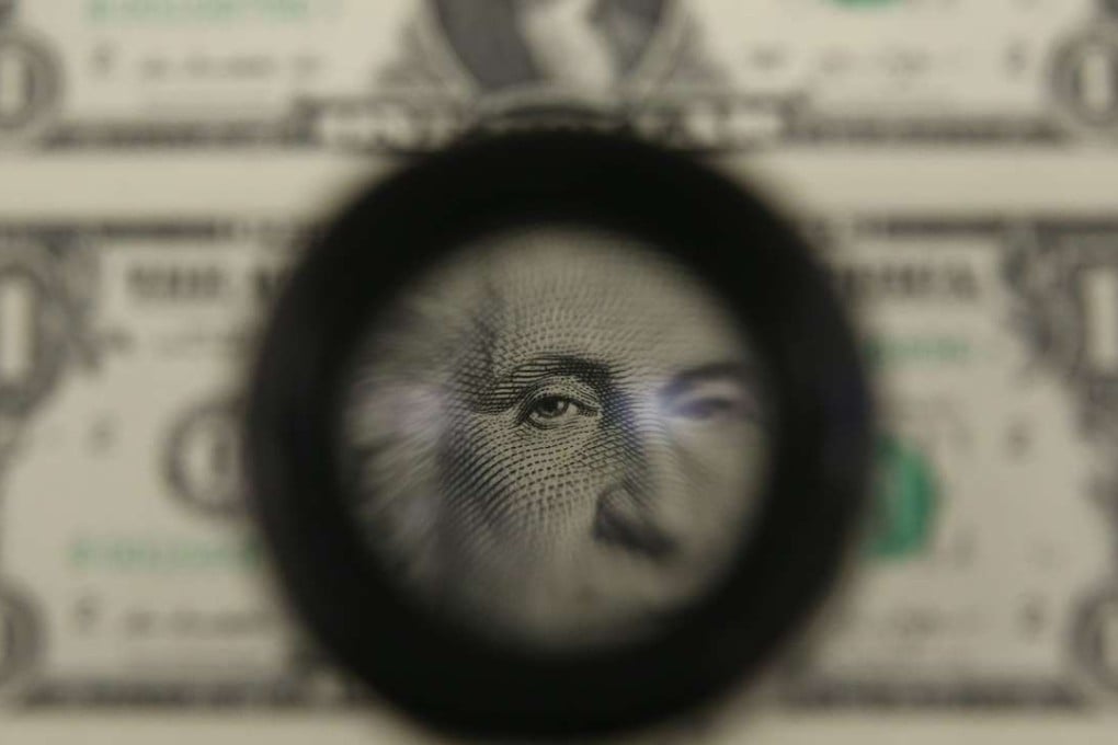 A magnifying glass is used to inspect newly printed one dollar bills at the Bureau of Engraving and Printing in March 2015 in Washington, DC. Photo: Getty Images.