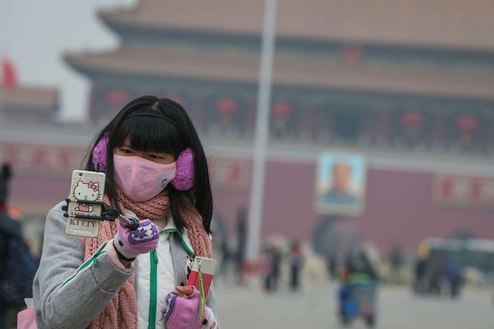 A woman pictured wearing a face mask in Tiananmen Square last month to protect against smog. Photo: EPA