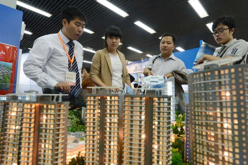 People view a model of a property development being sold at the Beijing Property and Investment Show. Photo: AFP
