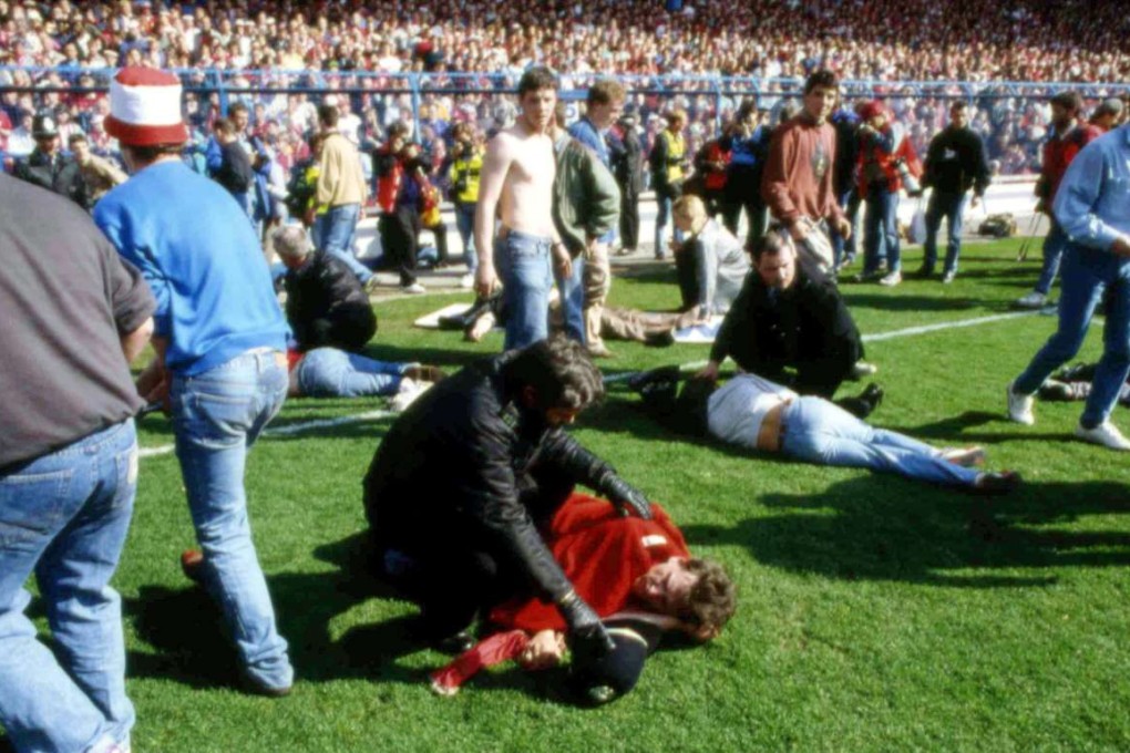 FILE - In this April 15, 1989 file photo, showing police, stewards and supporters as they tend to wounded soccer supporters on the field at Hillsborough Stadium, in Sheffield, England. 96 Liverpool fans were crushed to death in the incident at the FA Cup semi-final match Liverpool against Nottingham Forest. After a long campaign by relatives of the 96 soccer fans who were crushed to death in Britain’s worst sporting disaster, some 400,000 pages of previously undisclosed papers will be released Wednesday Sept. 12, 2012, and the previously secret documents may clarify what caused the disaster and how mistakes by British authorities may have contributed to the 1989 tragedy. (AP Photo, File)