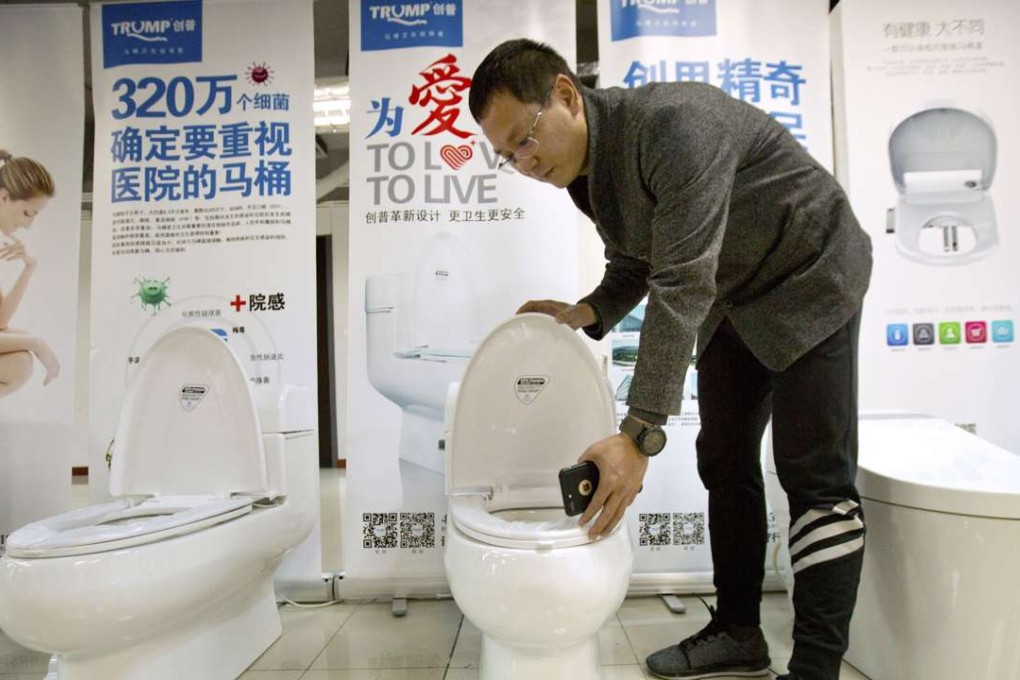 Zhong Jiye, a co-founder of Shenzhen Trump Industrial Co pictured with one of the firm’s Trump-branded toilets. Photo: AP
