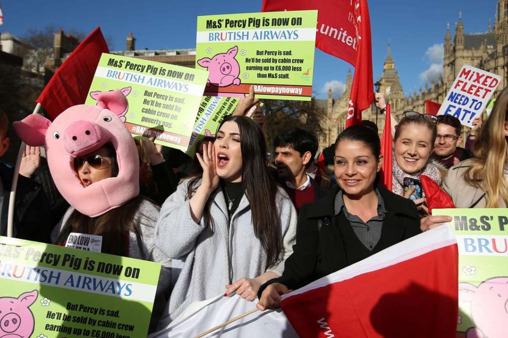 Demonstrators hold placards and wave flags as they protest against the low wages of British Airways' staff, outside the Houses of Parliament in London on February 7. Photo: AFP