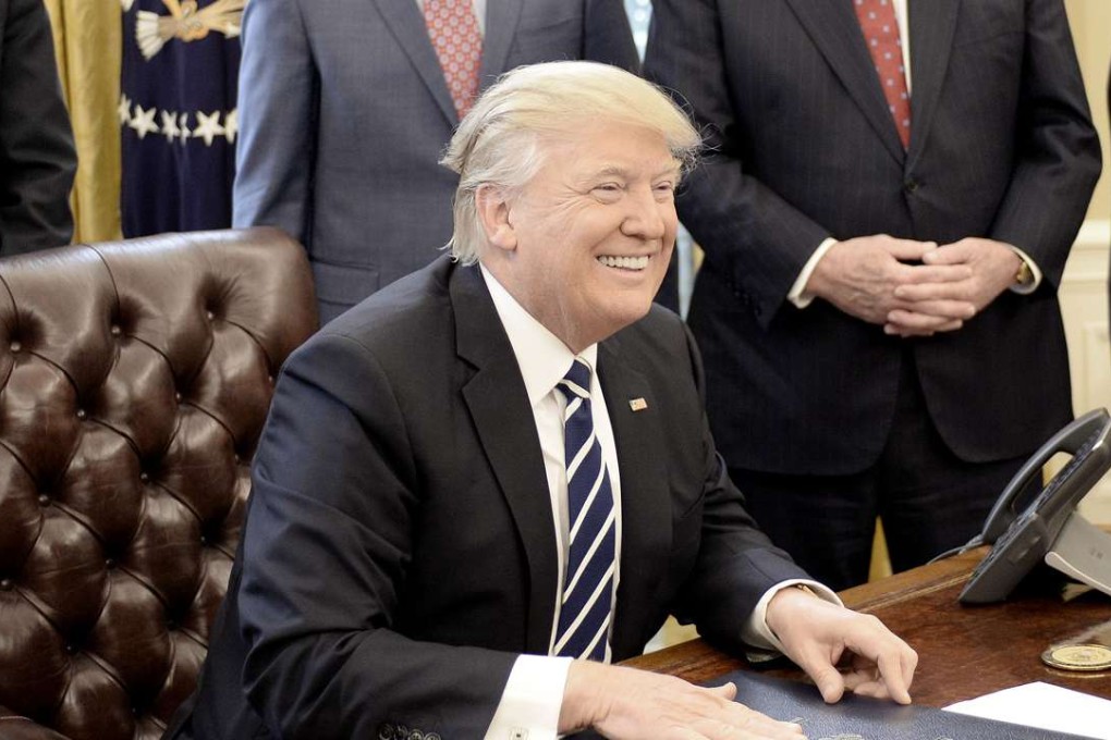 US President Donald Trump smiles after signing a resolution from the House of Representatives in the Oval Office of the White House. Photo: Abaca Press/TNS