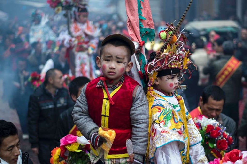 Locals carry children in palanquins during a festival as they parade through the village of Tufang in eastern China's Fujian province. Photo: AFP