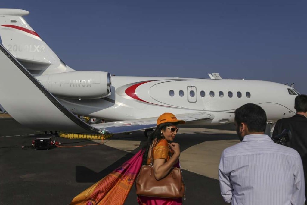 Attendees walk past a Dassault Aviation SA Falcon 20000LXS aircraft during the Aero India air show at Air Force Station Yelahanka in Bengaluru. Photo: Bloomberg