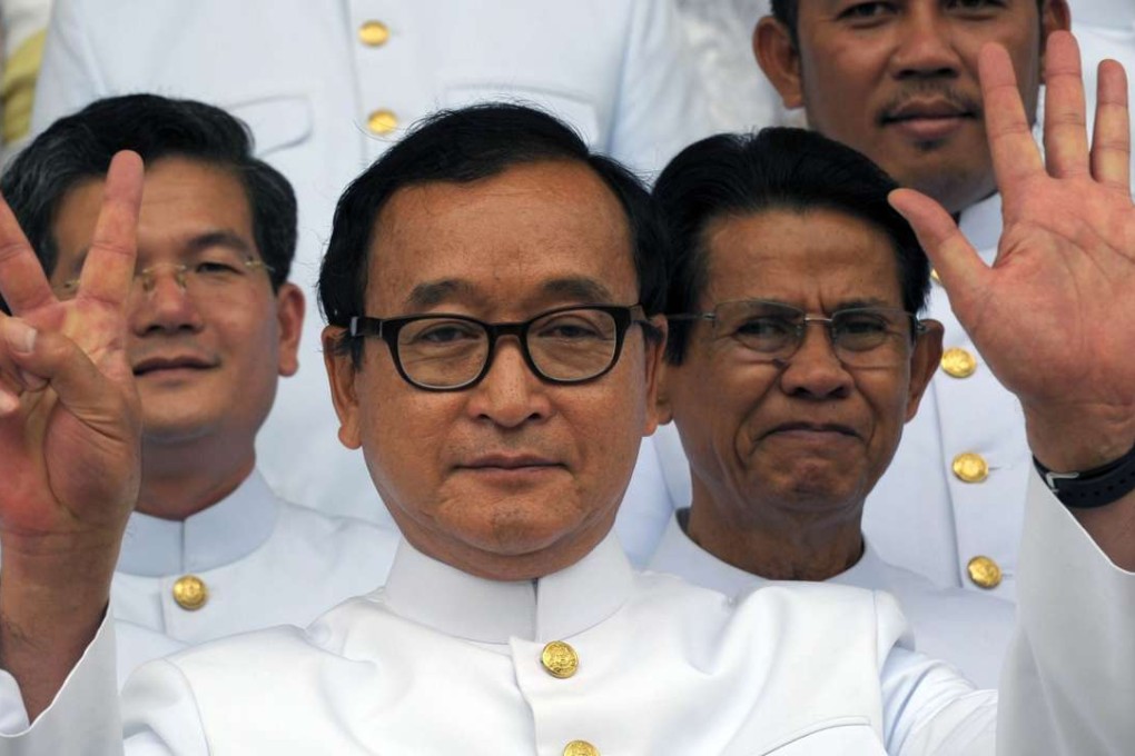 Cambodian opposition leader Sam Rainsy gestures out of the National Assembly building before the swearing in ceremony inside the Royal Palace in Phnom Penh in 2014. Photo: AFP