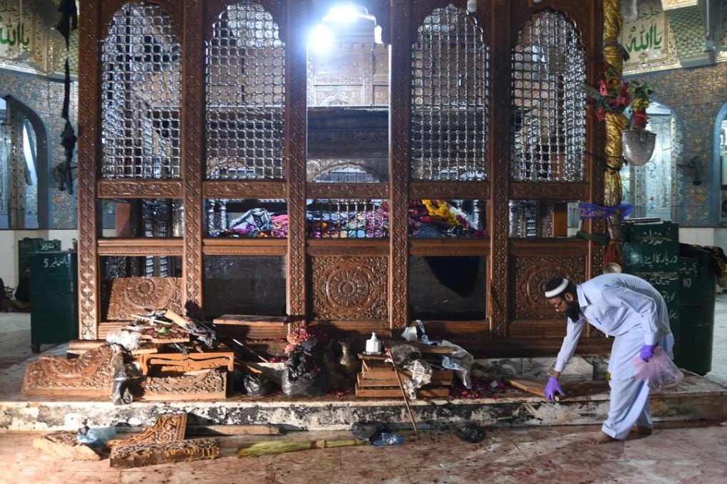 A Pakistani security official collects evidence on Friday, a day after a bomb attack hit the 13th century Muslim Sufi shrine of Lal Shahbaz Qalandar in the town of Sehwan in Sindh province. Photo: AFP