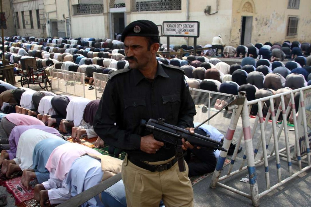 A Pakistani security official stands guard outside the mosque during Friday prayer. Photo: EPA