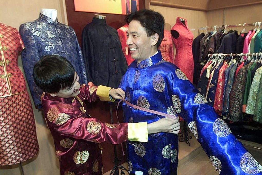 A salesman at Beijing's Daxin Textile Shop tape-measures the fit of a jacket for a customer. Photo: AFP