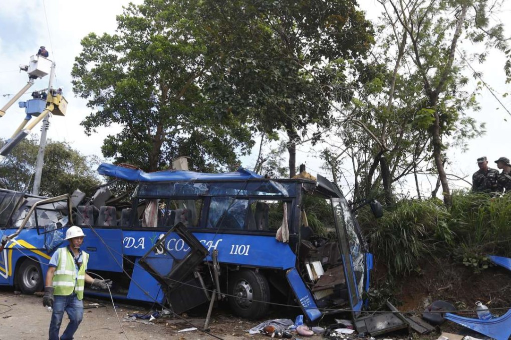 Workers look at a wreckage of a bus following a deadly accident. Photo: EPA