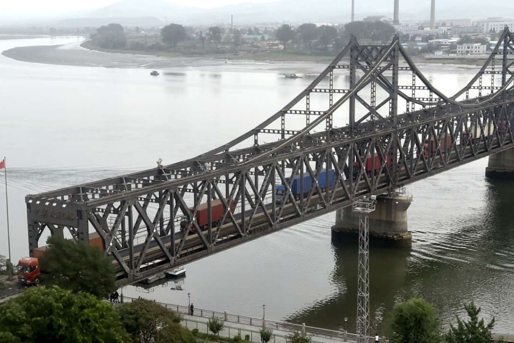 Trucks from North Korea cross a bridge on the border with China in this photo taken from Dandong in China's Liaoning province in September. Beijing said it would suspend all imports of coal from North Korea for at least the remainder of the year. Photo: Kyodo