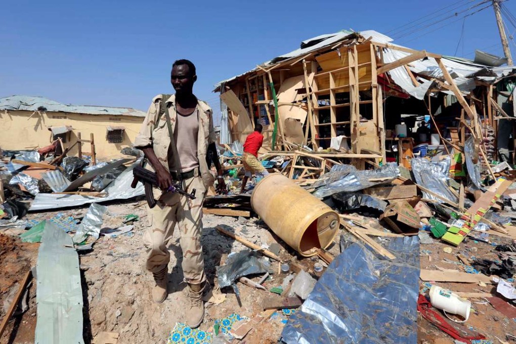 A Somali government soldier walks past the scene of a suicide bomb explosion at the Wadajir market in Madina district of Somalia's capital Mogadishu on Sunday. Photo: Reuters