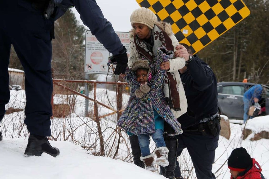 A asylum seeker who told police that she and her family were from Sudan is taken into custody by Royal Canadian Mounted Police officers after arriving by taxi and walking across the US-Canada border into Hemmingford, Quebec, on February 12. Photo: Reuters