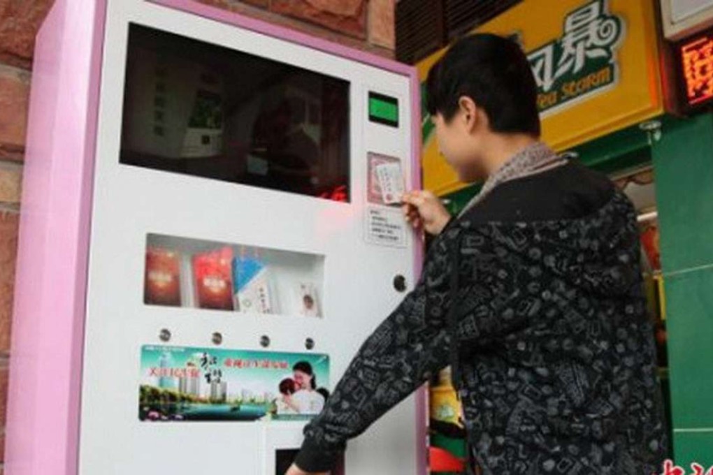 A man buys a pack of condoms from a vending machine in China. Photo: Handout