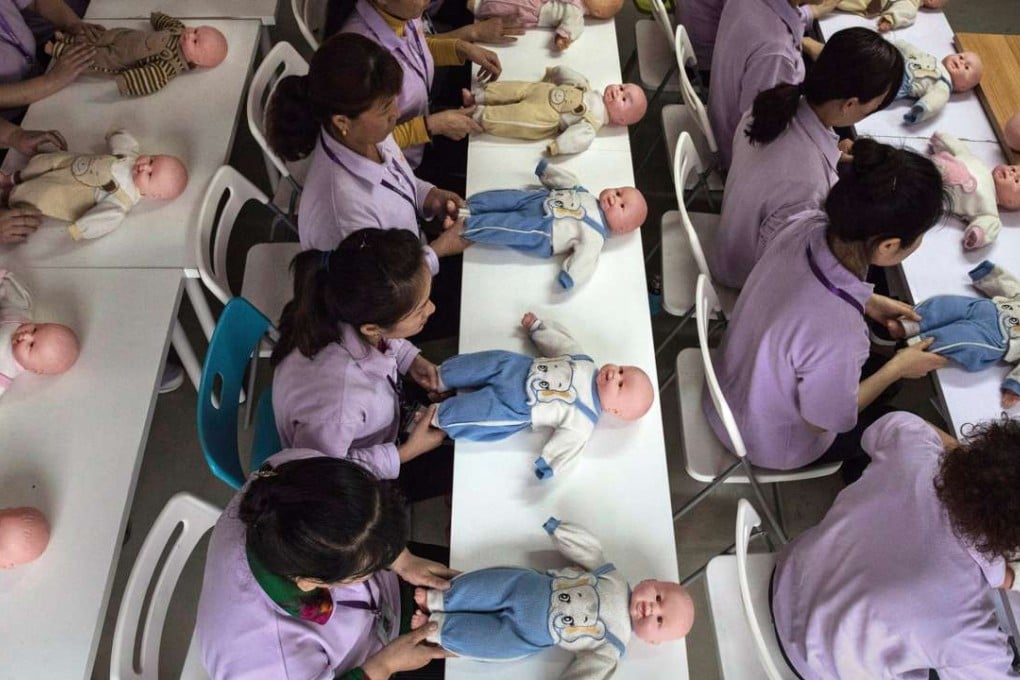 Women learn play techniques with a plastic baby at the Ayi University in Beijing, China. Photo: Getty Images