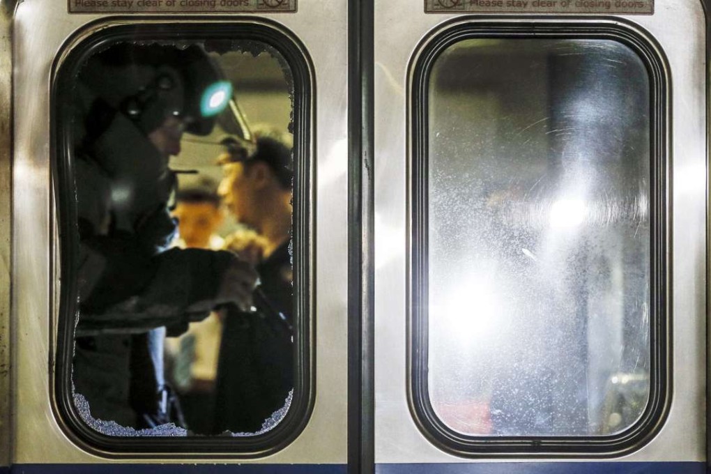 epa05413187 A member of a bomb squad is seen through a broken glass door of a train carriage after an explosion at Songshan train station in Taipei, Taiwan, 07 July 2016. According to news reports, the number of injured passengers might be up to 13 or 20, with some of them being sent to hospital by ambulance. Ongoing investigation is being conducted to find the cause of the explosion. EPA/RITCHIE B. TONGO