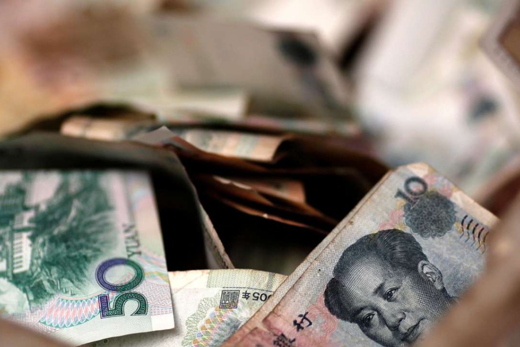 Chinese banknotes are seen at a vendor's cash box at a market in Beijing. Photo: Reuters