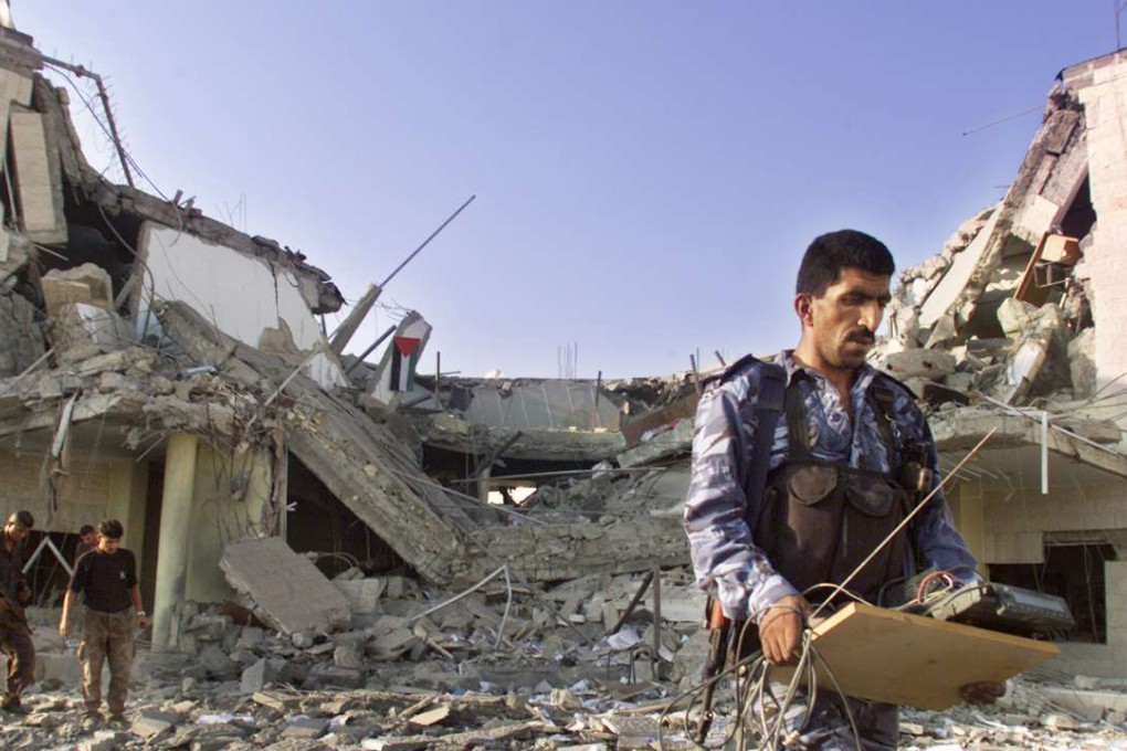 Palestinian police remove equipment from the rubble of the police station in the West Bank town of Ramallah that Israeli forces bombed in 2001. Photo: AP