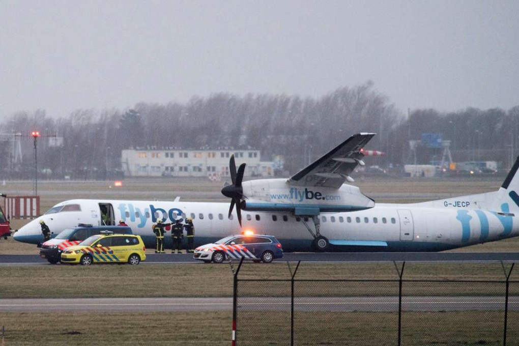 A plane of FlyBe airlines is seen off the runway of Amsterdam’s Schiphol airport after its landing gear broke in high winds. Photo: Reuters