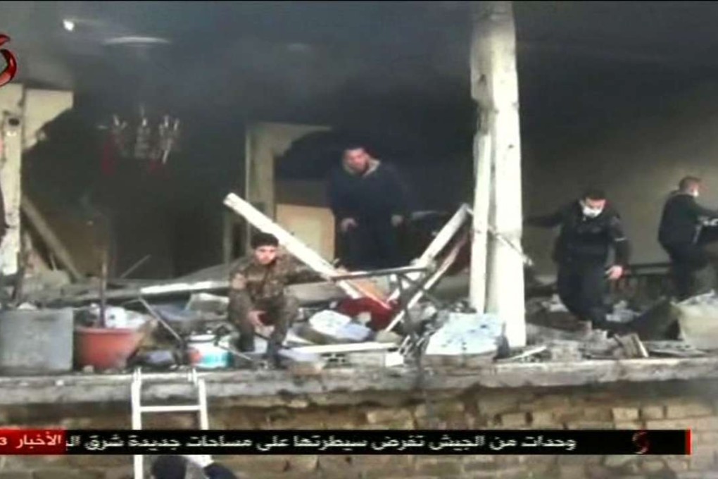An image grab taken from a video broadcasted by the Al-Ikhbariya Al-Souriya TV channel shows rescue workers at the site of a suicide attack targeting two security service headquarters in Syria's third city, Homs. Photo: AFP