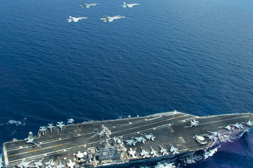 A US Navy handout photo shows two F/A-18 Super Hornets (L and R) and two Royal Malaysian Air Force SU-30MKM/Flanker H, flying above the aircraft carrier USS Carl Vinson, operating in the South China Sea during a bi-lateral exercise. The Vinson aircraft carrier strike group is patrolling the South China Sea, the US Navy said. Photo: US Navy via AFP