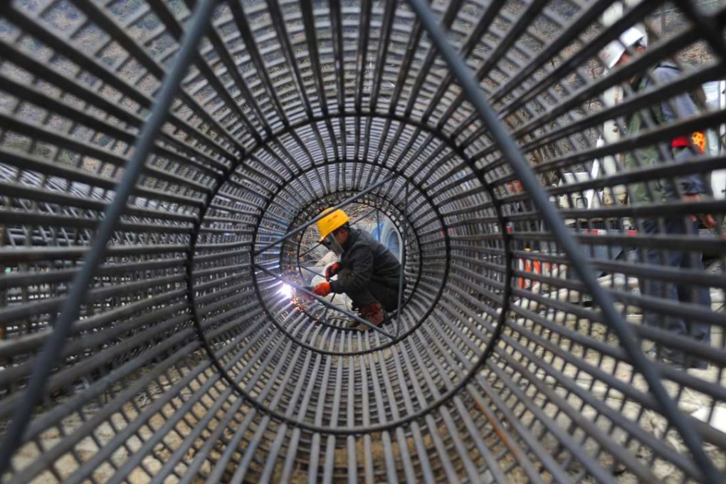 A worker welds steel reinforcements on a highway in Tibet. Many local authorities in China are using alternative channels to pay for costly infrastructure projects and boost their economies. Photo: Xinhua
