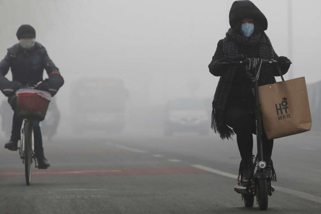 Cyclists venture out into the smog in Beijing earlier this month. Photo: Reuters