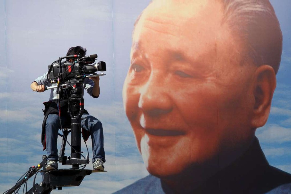 A cameraman shoots video next to a Deng Xiaoping billboard at the Lizhi Park in Shenzhen. Photo: Dickson Lee