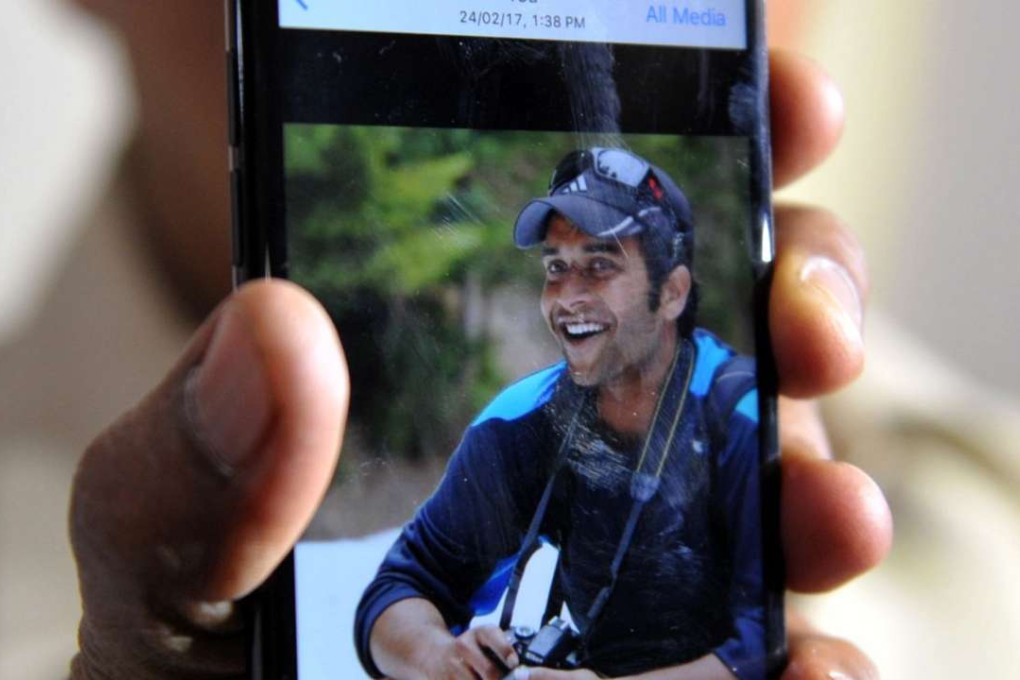 Jagan Mohan Reddy showing a picture of his injured son, Alok Madasani. Photo: AFP