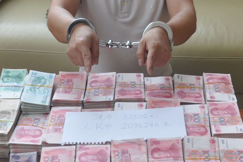 A suspect in an illegal banking operation in Guangdong province is pictured with some of the cash seized in a police operation. Photo: Handout