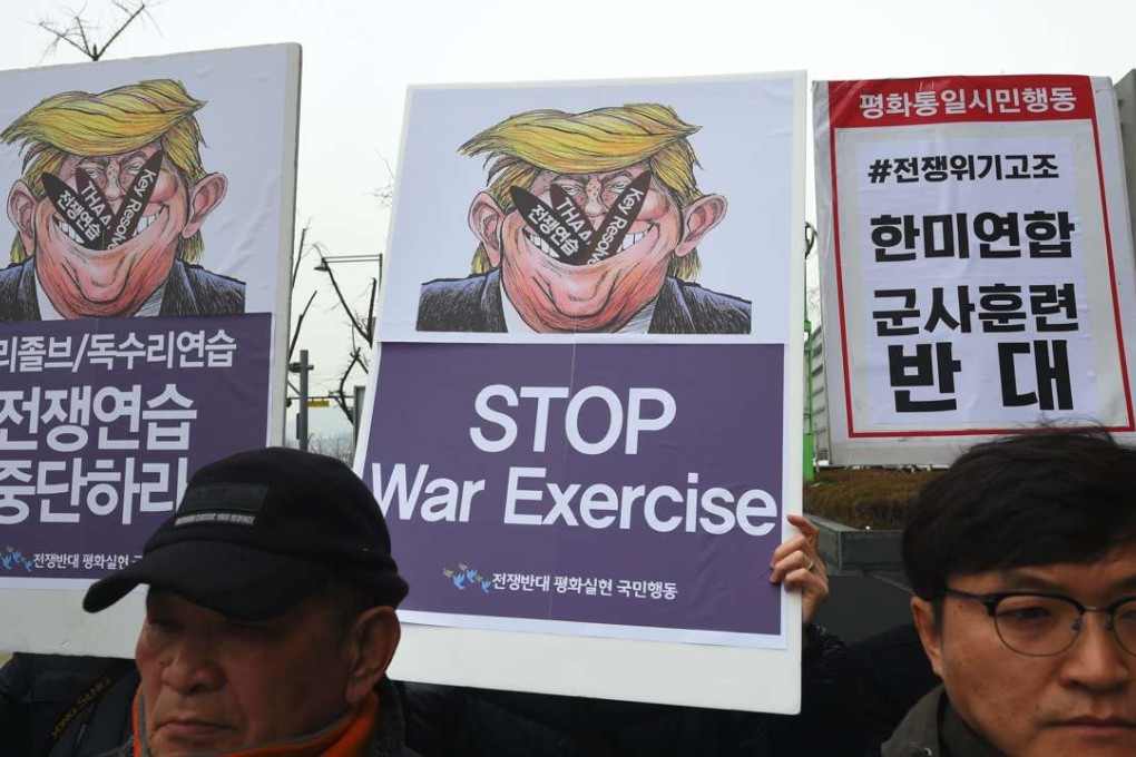 South Korean anti-war activists hold placards showing a caricature of US President Donald Trump during a rally against South Korea-US joint military exercises - known as Key Resolve and Foal Eagle - near the US embassy in Seoul. Photo: AFP